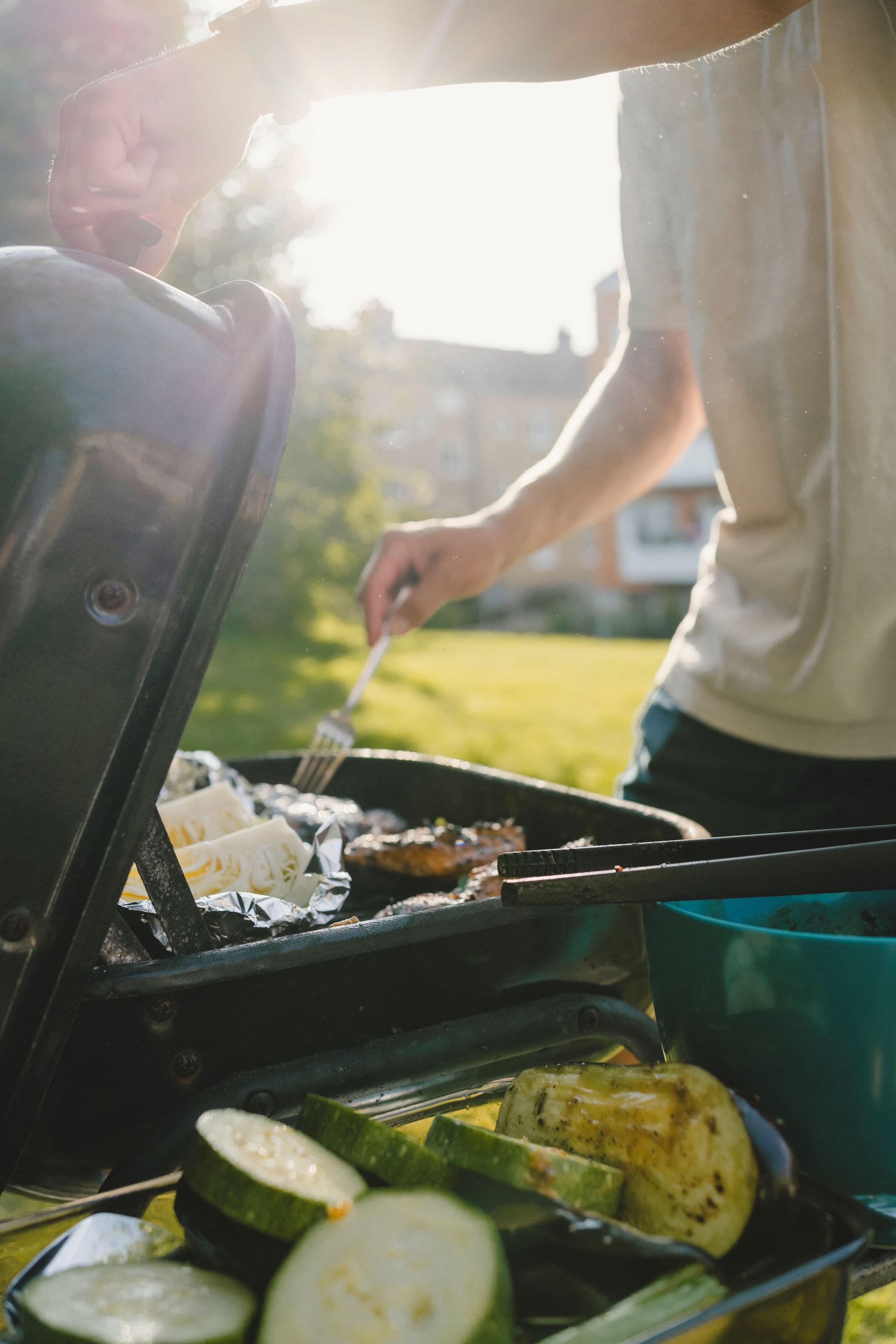 Man som grillar i trädgården