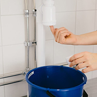 Bild på hink under vattenlås när man skruvat loss botten.