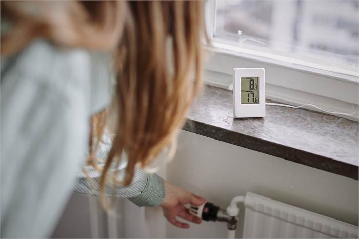 Boende som justerar radiatoren på värme